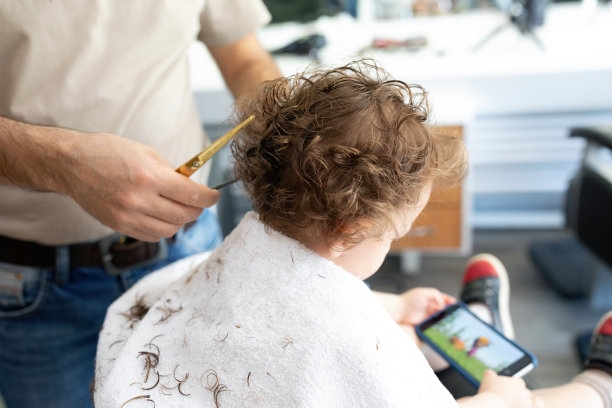 理发店里一个快乐的金发小孩的发型图片下载