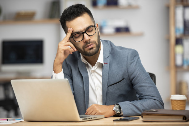 一个英俊的年轻商人在办公室工作的肖像图片下载