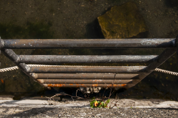 一个旧的生锈的梯子通向水里图片下载