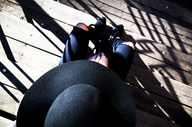 一个戴软呢帽的女人坐在楼梯上，看不见她的脸图片下载