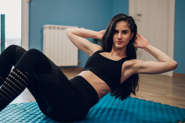 漂亮的年轻女子在家训练时做俯卧撑图片下载