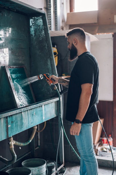 男工人在印刷车间用水清洗网框图片下载