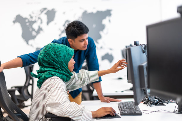 多民族创业团队阿拉伯妇女戴着头巾，在现代开放式办公室室内进行头脑风暴，在笔记本电脑和台式电脑上工作。有选择性的重点图片下载