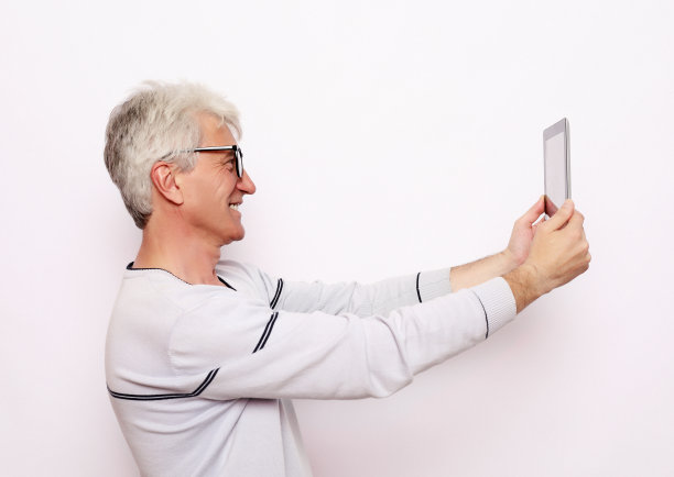 一位白发苍苍的老人用平板电脑与家人交流图片下载