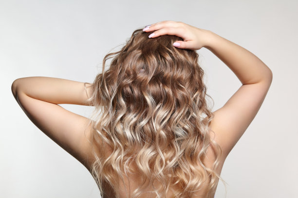 灰色背景上的女人。卷发女性图片下载