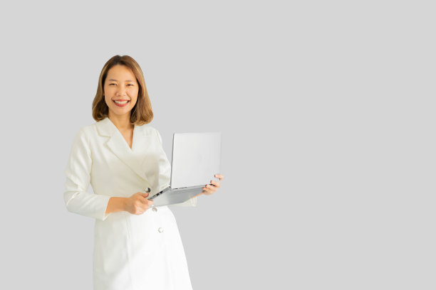 近距离亚洲女商人使用笔记本电脑和微笑孤立在灰色背景的商业和技术概念图片下载