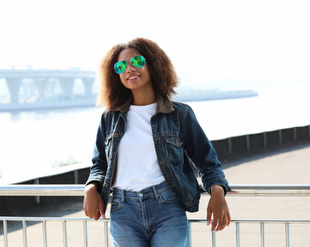 漂亮的女人戴着太阳镜，有完美的牙齿和黑干净的皮肤在户外休息图片下载