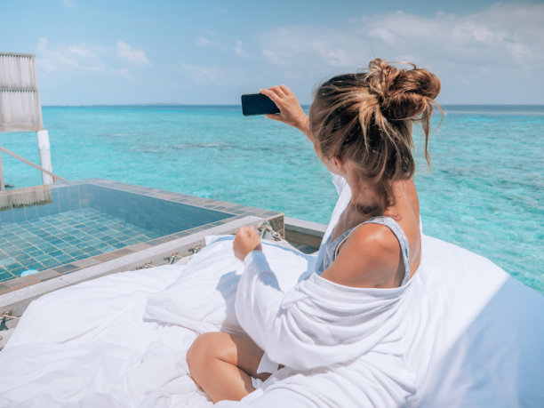 一名女子在豪华酒店休息，她用手机拍照图片下载