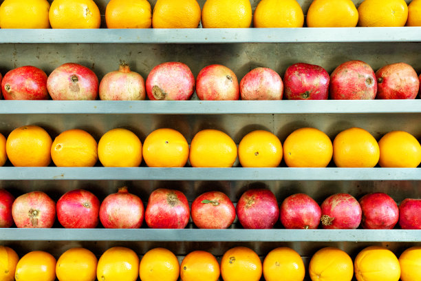 街边水果店货架上的石榴、橙子。图片下载