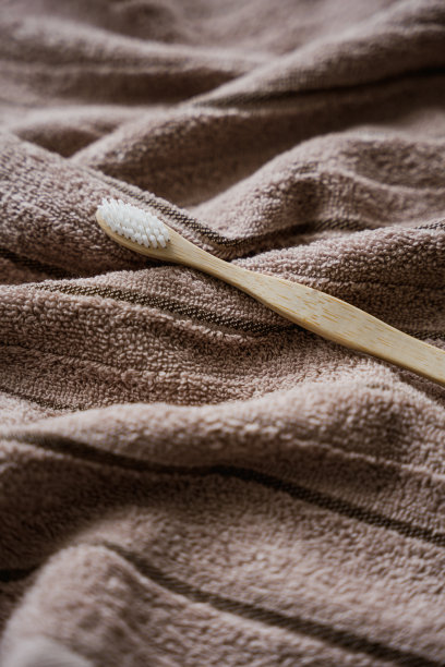 一个木制牙刷在毛巾上的特写图片下载