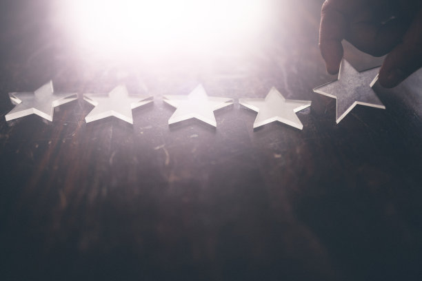 在木桌上手工排列5颗星。图片下载