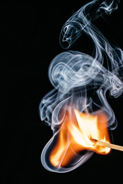 一根点燃的火柴棒在黑色背景前的特写图片下载