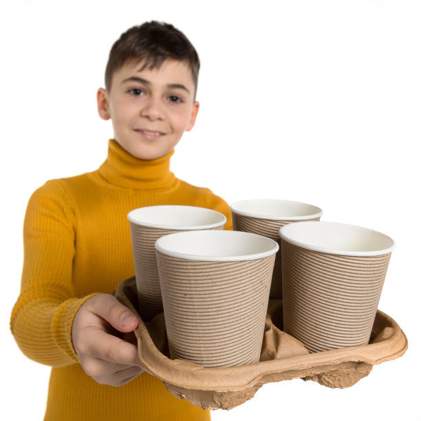 穿着黄色毛衣的活泼男孩托着一个托盘，上面放着四杯茶或咖啡，送货理念，选择性专注图片下载