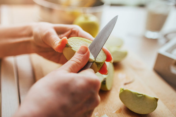 女性的手用小刀从苹果上切下一个核图片下载
