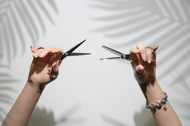 理发师的剪刀在一个女孩的手中。美丽的手拿着剪刀。图片下载