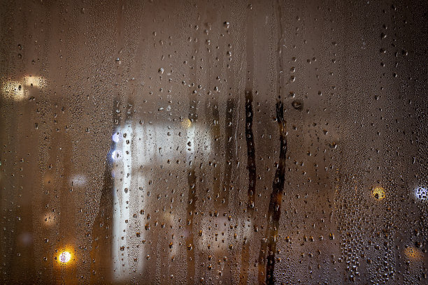 晚上的照片。水滴在玻璃窗上图片下载