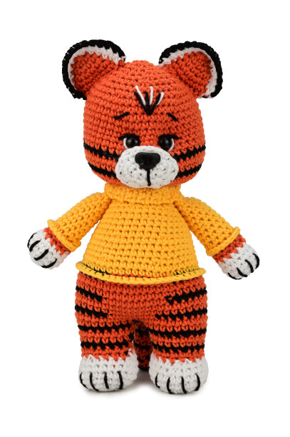 玩具虎。柔软的，钩编的玩具，穿着一件黄色的毛衣。孤立在白色背景上图片下载