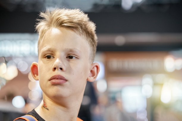 一个金发少年坐在候机室里图片下载