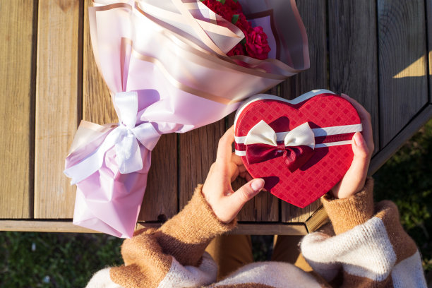 情人节框架与红心礼盒和红色的花装饰在乡村木制背景。图片下载