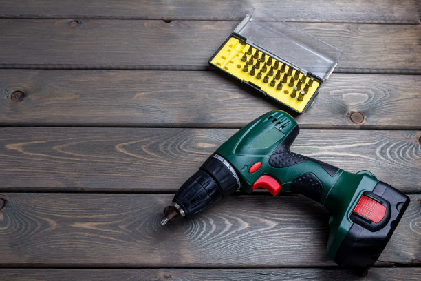 木制背景上不同位的无绳螺丝刀图片下载