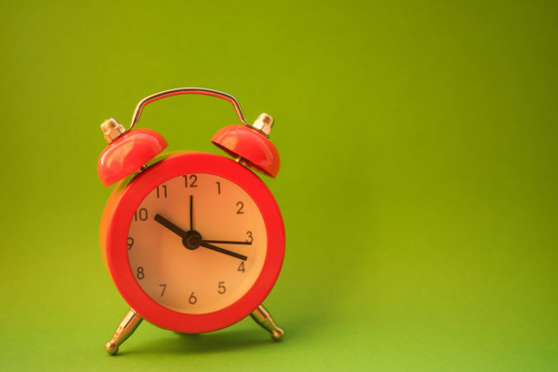 绿色桌子上的新红色圆钟，侧视图，复制空间图片下载