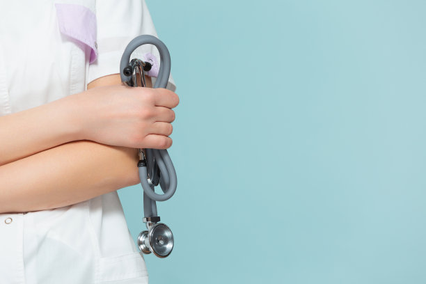 蓝色背景下手持听诊器的女医生的肖像图片下载