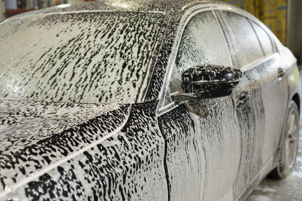 洗车房的车。泡沫车。白色的肥皂溶液。清洁的交通工具。图片下载