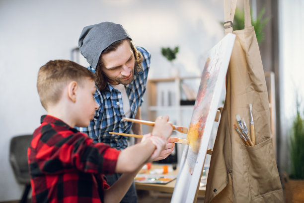 儿子和父亲用画笔和颜料画画图片下载