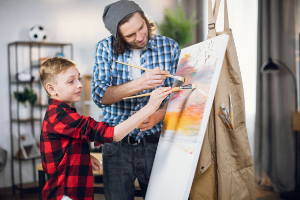 父亲帮儿子用画笔在画布上画画图片下载