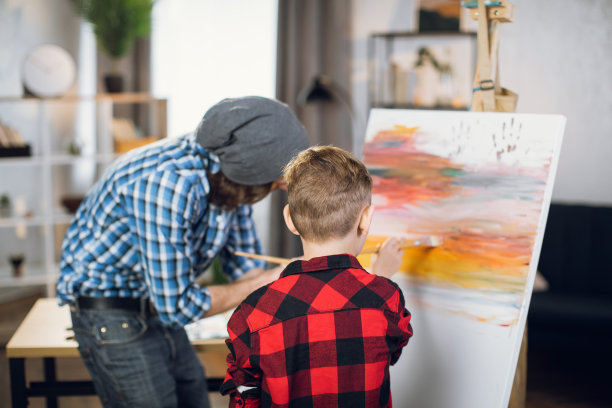 儿子和父亲用画笔和颜料画画图片下载