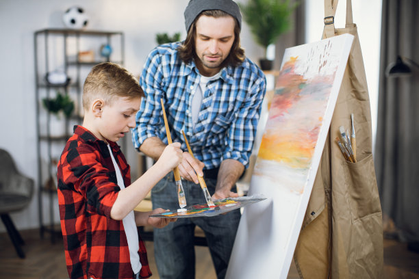 父亲花时间陪儿子在画架上画画图片下载