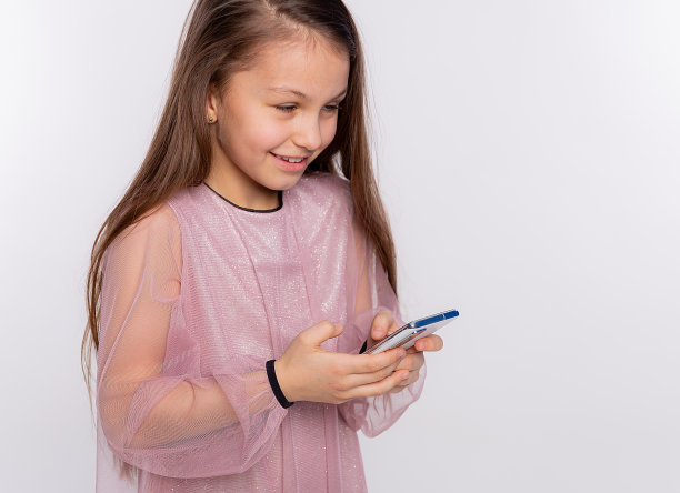 白人小女孩看屏幕的手机看视频或打字文字，孤立在白色背景自由空间为你的文字图片下载