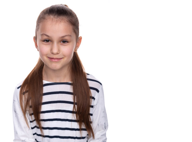 一个快乐微笑的小女孩的肖像。可爱的8岁小女孩被隔离在白色的背景上图片下载