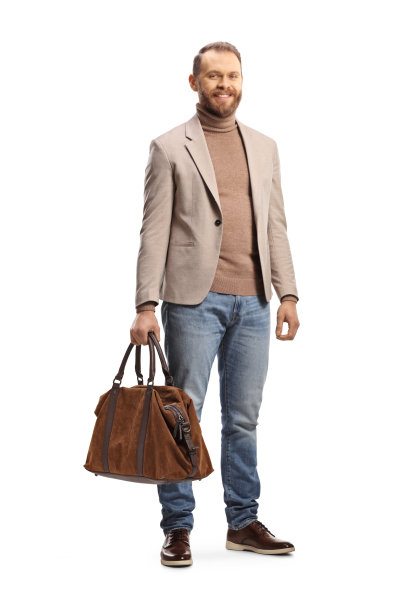 一名职业男子的全身肖像，穿着米色西装和牛仔裤，拿着一个包图片下载