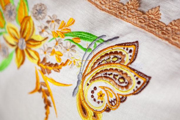 彩色的刺绣设计在花和蝴蝶的形式，在一个白色的亚麻枕头，特写镜头。图片下载