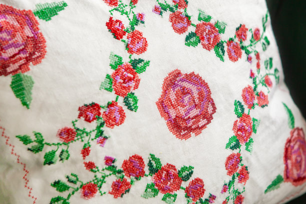 装饰元素，十字绣玫瑰花，在白色亚麻布织物上。绣花机,特写图片下载