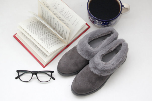 舒适的，毛绒的，有软垫的灰色拖鞋准备睡觉，懒洋洋的，放松的书，咖啡，和在床上的眼镜图片下载