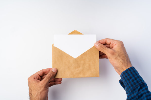 俯视图男性手握(打开)信封上面的白色背景图片下载
