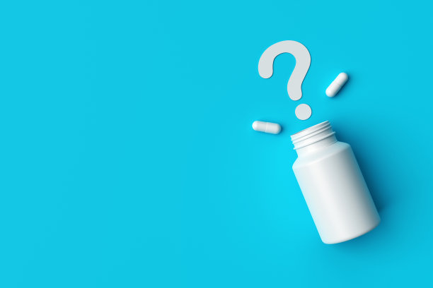 塑料医疗容器和白色胶囊药丸与蓝色背景上的问号顶视图。图片下载