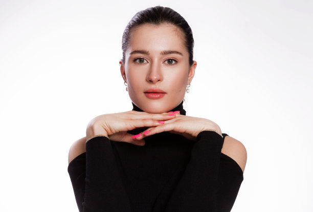 短发，皮肤干净的女人。脸近，皮肤美黑，美丽的微笑的女人在黑色高领在白色的背景图片下载