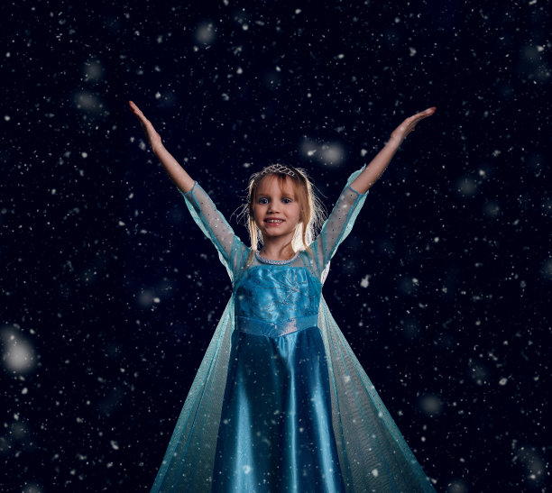 年轻的白雪公主。神秘幻想女孩在蓝色华丽的连衣裙。黑色艺术背景的冬天冰天雪地。图片下载