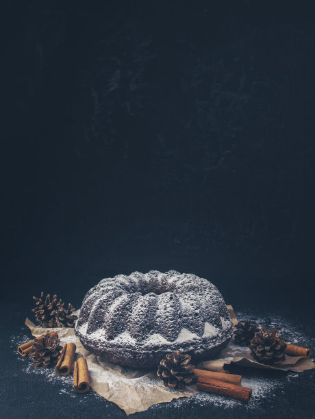 圣诞蛋糕和装饰，黑色的背景“新的一年。圣诞甜点。家庭庆祝活动。假期。块蛋糕图片下载