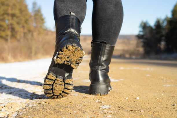 背景照片的女人脚穿冬天的鞋走在路上，旅行者在周末阳光明媚的日子。图片下载