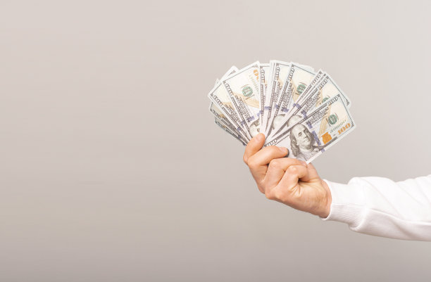 一个男人手里拿着很多钱的特写照片图片下载