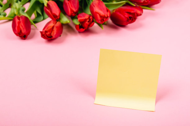 大节日红色郁金香花束和干净的贴纸在一个粉红色的背景与复制空间。经营理念。撕掉纸为笔记，提醒或快速临时消息，组织者的想法和想法图片下载