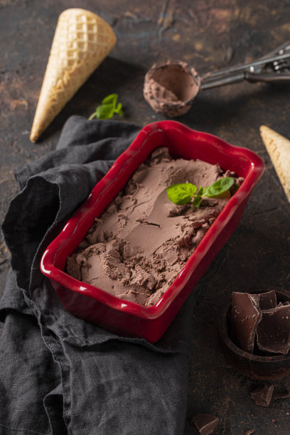 自制的巧克力冰淇淋在一个碗里与巧克力和薄荷在黑暗的桌子上垂直的照片图片下载
