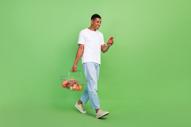全尺寸的侧面照片年轻的非洲人类型浏览手机购物中心孤立在绿色的背景图片下载