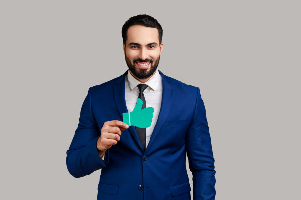 英俊的大胡子商人微笑着看着镜头，竖起大拇指。图片下载