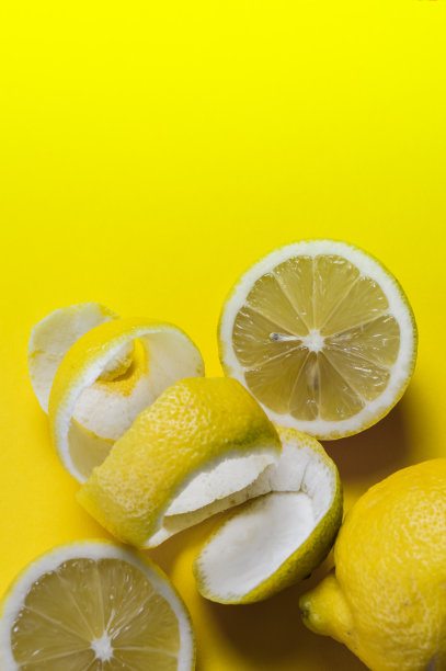 在黄色的纸上，对一些文字有足够的空间，减半的柠檬和螺旋柠檬皮的快乐背景图片下载