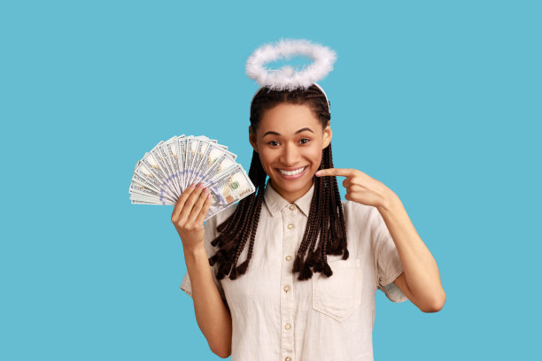 天使般的女人，留着长发绺，头脑敏捷，手里拿着并指着一扇钞票。图片下载